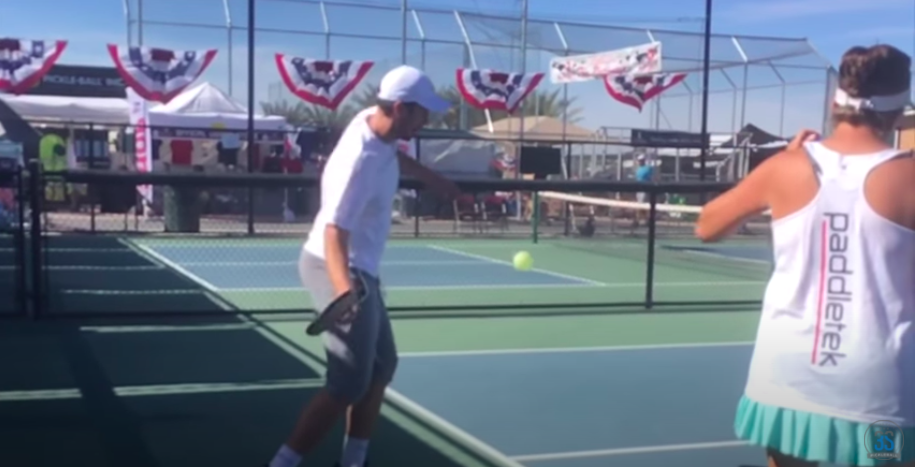 Pickleball serve with paddle moving upwards